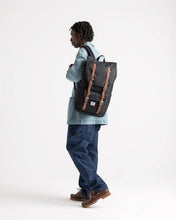 Load image into Gallery viewer, A young man facing left while carrying a black backpack with tan accents.