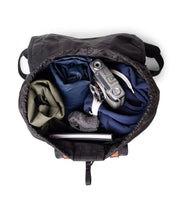 Load image into Gallery viewer, Interior view of the Little America backpack with clothes and travel accessories in the main compartment.