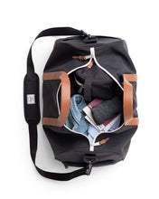 Load image into Gallery viewer, Interior view of the tan and black duffle bag with clothes and accessories inside the main compartment.