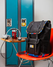 Load image into Gallery viewer, The backpack placed on a school desk by a locker.