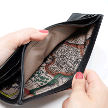 Load image into Gallery viewer, A pair of hands holding open the wallet's bill compartment. It features a map print on the lining.