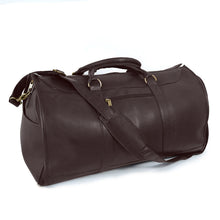 Load image into Gallery viewer, Angled front view of the brown leather garment duffle bag. The shoulder strap is resting diagonally across the top and front.