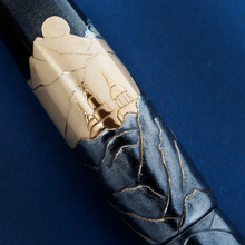 Load image into Gallery viewer, Close up to a set of buildings painted on the background of the cap. Placed on a blue background.