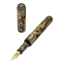Load image into Gallery viewer, Angled view of the Fountain Pen with the cap set to the side on a white background. It features a scenery of flowers, foliage and fauna.