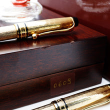 Load image into Gallery viewer, Close up to an arrangement of the writing instruments and the side of the presentation box. Two small dents on the wood are visible at the top edge