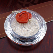 Load image into Gallery viewer, Close up to the included sand case, placed on top of the wooden presentation box. The top of the case has a wax seal with the Aurora logo on it.