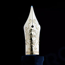 Load image into Gallery viewer, Close up to the yellow-gold fountain pen nib. Decorations and an engraving of 18K, 750, AURORA, and a hallmark are engraved on it.