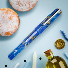 Load image into Gallery viewer, Front view of the pen with the cap on. Set on a light blue background with some accessories (not included).