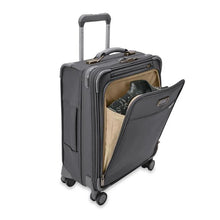 Load image into Gallery viewer, Angled view of the suitcase with the front panel unzipped. A jacket is folded into the compartment.