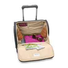 Load image into Gallery viewer, Interior view of the steel gray cabin spinner suitcase, filled with accessories. The fabric lining is light brown, and features a set of organizational pockets on the sides.