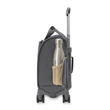 Load image into Gallery viewer, Side view of the steel gray baseline cabin spinner suitcase. It features an elasticized mesh to conveniently hold a water bottle or small travel thermos.
