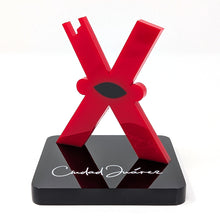 Load image into Gallery viewer, Front view of the letter 'X'. A small black eye-shapped figure is at the center.