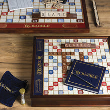 Load image into Gallery viewer, Two Scrabble wooden boards arranged with the tiles and contents on a wooden table.