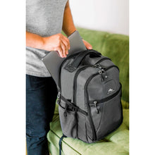 Load image into Gallery viewer, A man sliding a laptop into the backpack's back panel pocket.