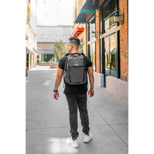 Load image into Gallery viewer, A young man carrying the backpack in an urban setting.