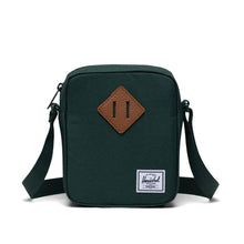 Load image into Gallery viewer, A green Herschel Heritage Cross-body bag with an adjustable strap, zippered closure, and a tan leather square to attach an accessory
