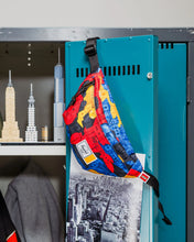 Load image into Gallery viewer, The Lego brick print hip pack hanging from a locker's door.