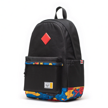 Load image into Gallery viewer, Angled front view of the black backpack with abstract colorful Lego brick fabric accents.