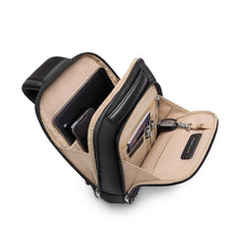 Load image into Gallery viewer, Briggs & Riley @work Sling shown in Black
Side Angle Image of Sling Pack showing   both main compartment and front organizer compartment with dedicated pen and card slots, key holder and slip pocket for passport and airline ticket.
Dimensions:  13 x 8.5 x 4 in / 33 x 21.6 x 10.2 cm