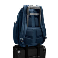 Load image into Gallery viewer, Briggs & Riley @Work Large Cargo Backpack in Navy
Image of Back Panel with attachment feature engaged allowing for Backpack to ride along the telescoping handles of your carry-on trolley.
Dimensions: 18.75 x 16 x 8.75 in / 47.6 x 40.6 x 22.2 cm
