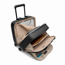 Load image into Gallery viewer, Angled view of the black medium spinner brief with all the zippers opened. A folded sweater, laptop, book, passport, and accessories are organized in different compartments.
