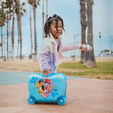 Load image into Gallery viewer, A smiling child kicking the air while leaning on the Paw Patrol suitcase.