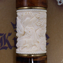 Load image into Gallery viewer, Close up to the ivory dinosaur carving, three dinosaurs are visible with foliage.