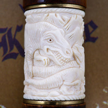 Load image into Gallery viewer, Close up to the ivory dinosaur carving showing the main area of the T. Rex face