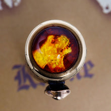 Load image into Gallery viewer, Close up to the top of the cap. The top cap features an amber disc emblazoned with an etched image of a T. Rex.