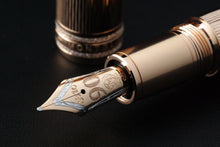 Load image into Gallery viewer, Close up to the Fountain Pen nib with the cap placed behind it. Set on a black background.