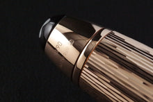 Load image into Gallery viewer, Close up to the edition and materials engraved on the cap. It is #38/90, made of AU750 Gold.