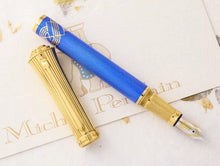 Load image into Gallery viewer, The Pen is laid on the certificate with the cap set off to the side. The grip section of the pen has an intricate decoration engraved around it. It is also gold plated to match the other trims.
