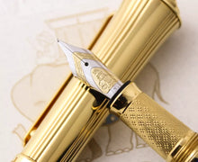 Load image into Gallery viewer, The pen's nib rests on top of the cap. The certificate is shown on the background. A close-up shows its engraved details: a set of leaves at the top, followed by '18k,' the Michel Perchin elephant, and the letter 'M' at the bottom, indicating a medium nib size.