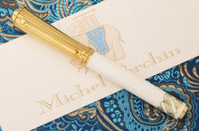 Load image into Gallery viewer, Front view of the fountain pen with the cap on. Set on top of the certificate and a blue embroidered fabric.
