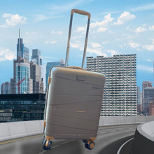 Load image into Gallery viewer, Image of the Mocha suitcase set on an urban background with buildings, the sky, and a freeway.