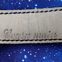 Load image into Gallery viewer, Close up to the inside of the watch strap. An embossing in cursive lettering reads: "Cousu main"
