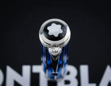 Load image into Gallery viewer, Close-up of the top of the blue and silver Montblanc pen with the brand's iconic six-pointed star logo on a black background.