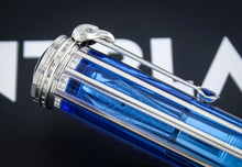 Load image into Gallery viewer, A close-up of the blue translucent pen with silver-toned gold accents, featuring a decorative cap and a sleek clip, set against a dark background with blurred white lettering.