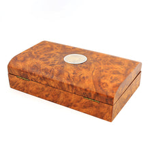 Load image into Gallery viewer, Angled view of the wooden presentation box. It has a slight red-brown color to it, and a decorated medal on the center of the lid.