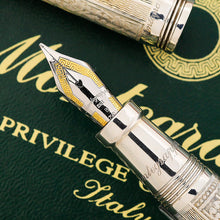 Load image into Gallery viewer, Close Up to the Pen's nib. The small hole for the ink flow is in the shape of a small heart. It features some simple engravings with golden accents. The word "Montegrappa" is engraved in cursive. The next line engraved is "ITALY", followed by the "B" for the nib size broad. The last line has a 750, to indicate it's made of 18k gold.