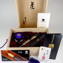 Load image into Gallery viewer, Fountain pen in display box, with inkwell, and documents on a white background.