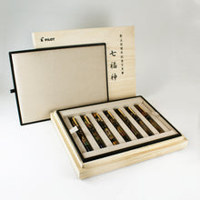 Load image into Gallery viewer, A wooden box with seven fountain pens arranged inside individual slots