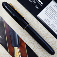 Load image into Gallery viewer, Side view of the fountain pen arranged on top of the outer box with the included pamphlets.