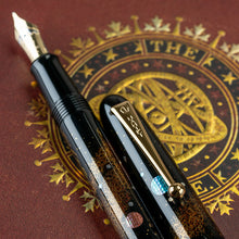 Load image into Gallery viewer, Angled view to a close Up of the pen's barrel and the clip. Two of the planets seen are made of Raden (mother of pearl pieces).