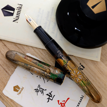 Load image into Gallery viewer, Front view of the fountain pen. The cap has been set to the side, with the ink bottle and the included certificates. Everything is placed on top of the wooden box's lid.