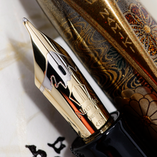 Load image into Gallery viewer, Close up to the Fountain Pen's nib. The nib is made of 18K gold, with a white design of the top of Mount Fuji engraved on it. Underneath, the Namiki logo is engraved, under it is the 18K-750 hallmark. Underneath, the engraving "<B>" shows the point is broad in size.