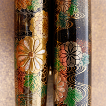 Load image into Gallery viewer, Close up to the design of the cap and the pen's flowers. Gold dust designs with delicate curled lines are painted on a black background. More gold dust is spread delicately around the flowers.