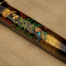 Load image into Gallery viewer, Close up to the blue abalone flower with green, gold dust and red lacquer foliage painted on the pen's barrel.