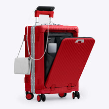 Load image into Gallery viewer, Angled front view of the red carry-on with the front panel opened. It is arranged with a charging cellphone, a small purse, and a laptop in its compartment.
