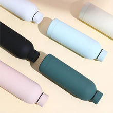 Load image into Gallery viewer, Set of colorful water bottles on a light beige background